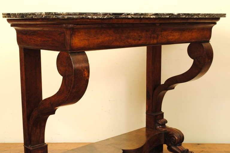 the rectangular marble top having rounded front corners atop a case housing a hidden drawer, straight rear supports and scrolled front supports ending at a lower shaped level and resting on well carved paw feet.