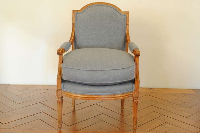 the rectangular backrest with arched top , the fluted armrests with rounded handles continuing to a molded apron, the seat having an overstuffed down cushion, the corners with carved medallions, the legs fluted and of tapering form

Please go to