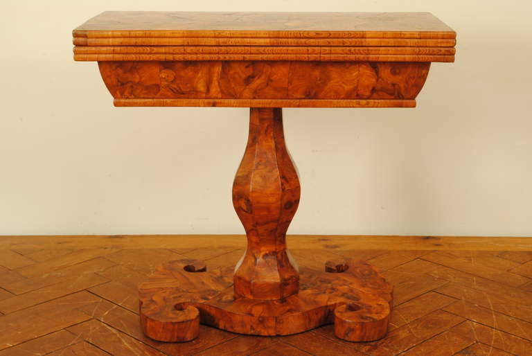having a double molded edge top above a double molded edge lower section joined by original brass hinges, the top opening and twisting to form a larger table and having a hidden storage well, raised on an octagonal shaped column, resting on a