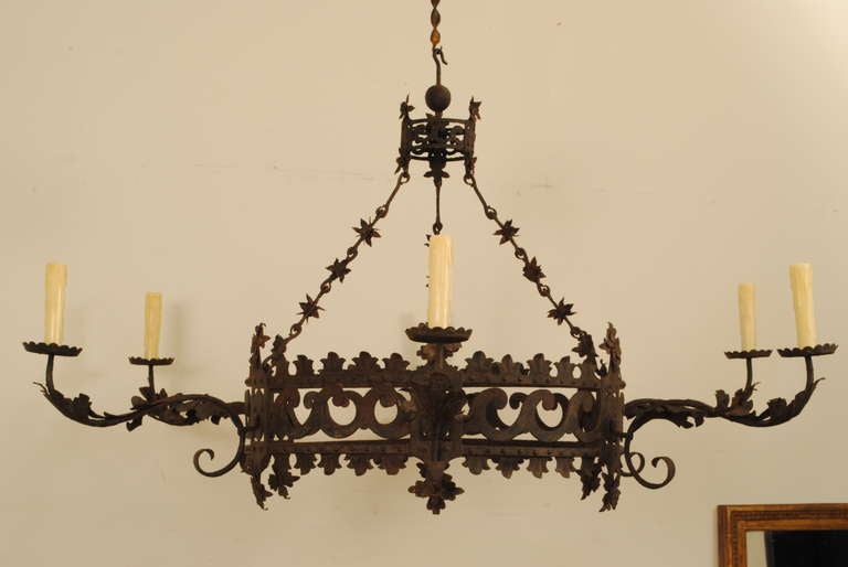 of double ring construction with a wave-form pattern within parallel bands, the upper section having rosettes above and below, the lower section with larger rosettes and a crenelated upper and lower edges, having original and elaborate hanging