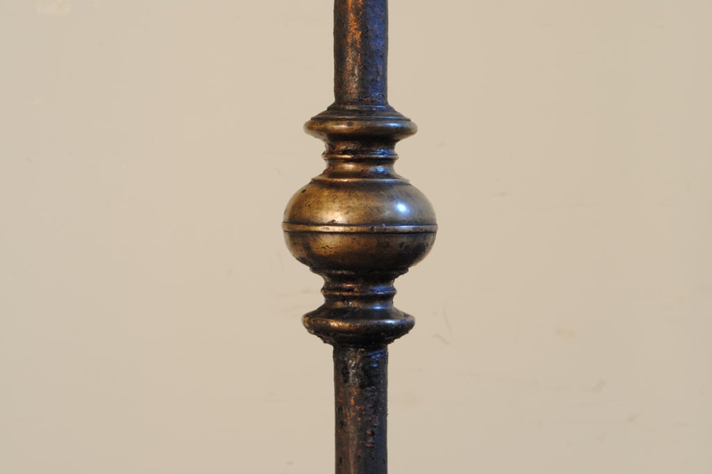 beautifully constructed hand wrought iron legs making up the bases consisting of c-scrolls and meeting at the bottom of the hand forged shafts encased by a forged brass terminal, the shafts decorated with two more forged brass fittings, the bobeches