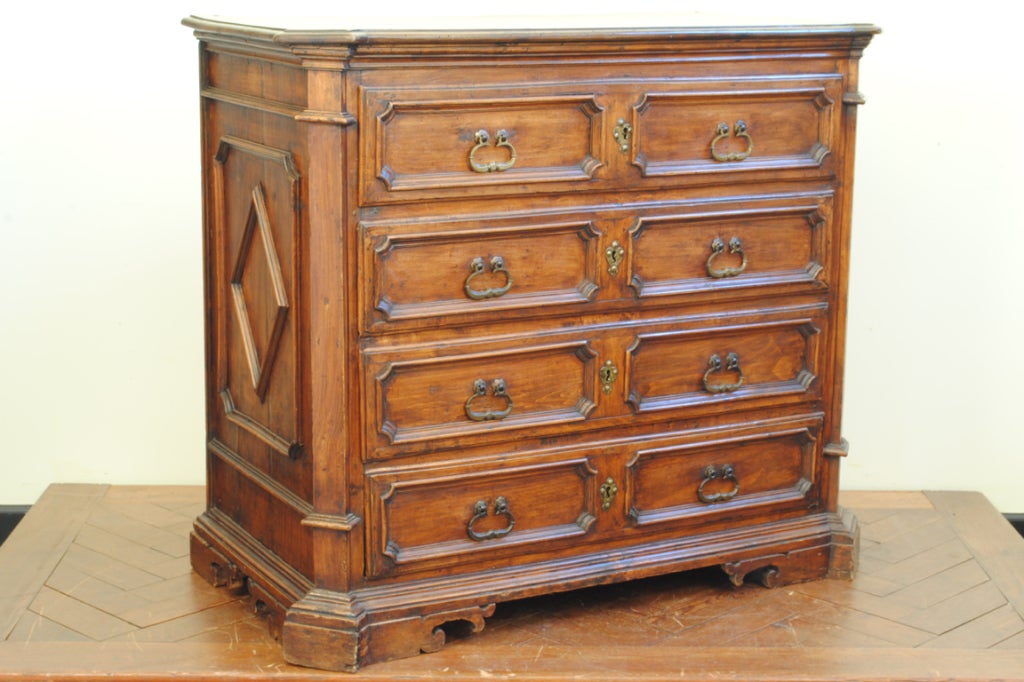 the rectangular top having stepped and canted corners above a conforming case, the sides having lozenge-form molding, the drawers with paneled sections and bronze handle pulls and escutcheons, raised on shaped bracket feet, two original keys