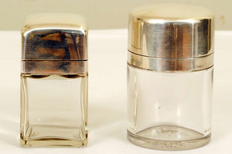 Each having a hinged top above a glass container complete with glass stopper, silver marks.

Cylinder measurements: Height: 4 in., diameter: 2.5 in,
cube measurements: Height: 3.75 in., length: 2 in., depth: 2 in.

Please go to www.robuck.co to