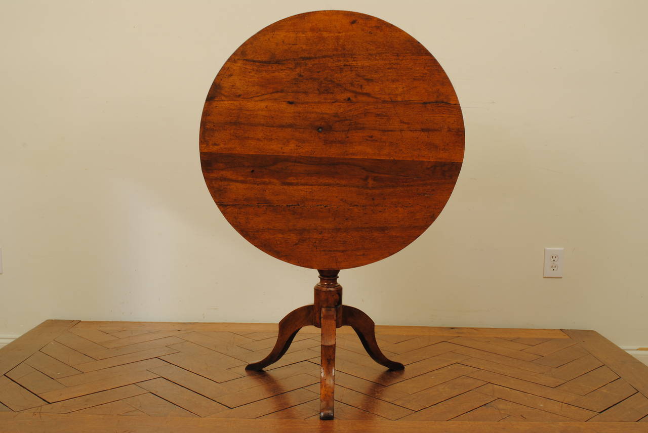Table having a round top atop and a turned column raised on a tripartite base with shaped legs and flattened feet.