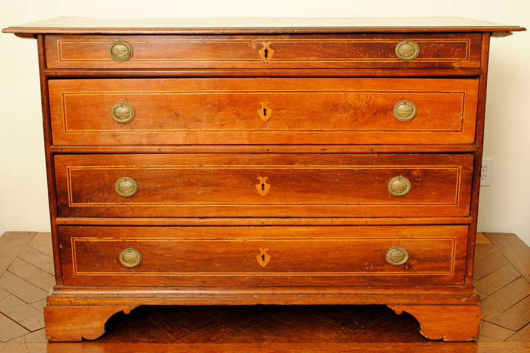 having a rectangular top above a conforming case housing 4 drawers with line inlays, the later brass pulls of ring form , inlaid escutcheons, raised on bracket feet

Please go to www.robuck.co to see our complete inventory.