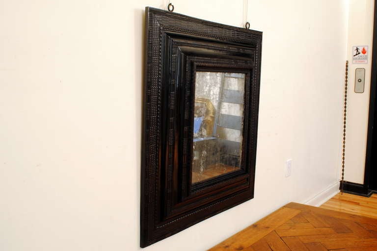 A Large Italian Early Baroque Period Carved and Ebonized Pinewood  Mirror