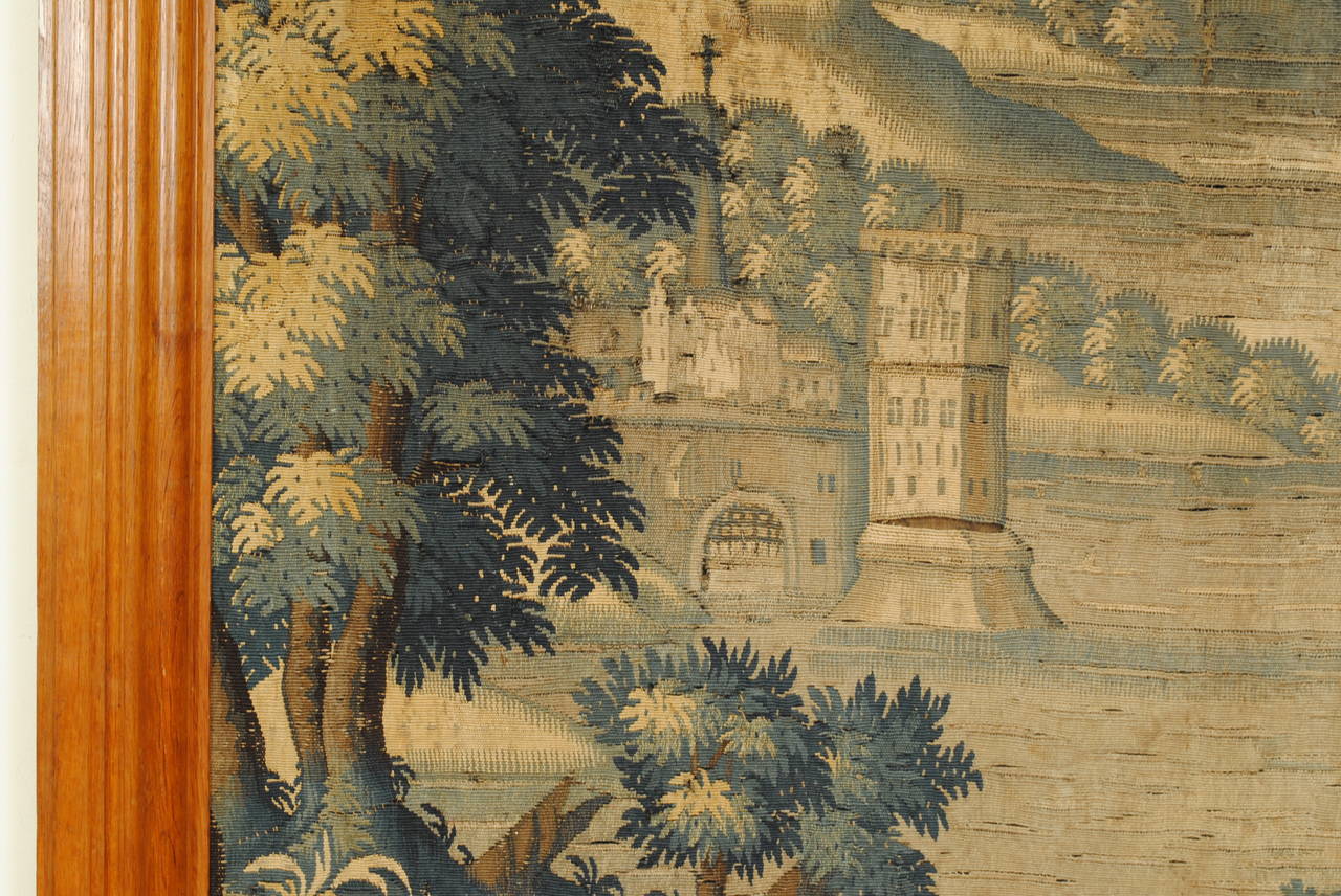 framed in pinewood, the tapestry depicting a castle, foliage, and animals