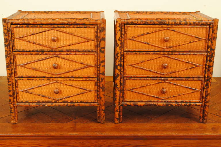 having been produced for Bloomingdales, the rectangular tops with raised rectangular molding trimmed with faux bamboo molding which continues throughout the commodes, having large molded lozenges at side panels and drawer fronts