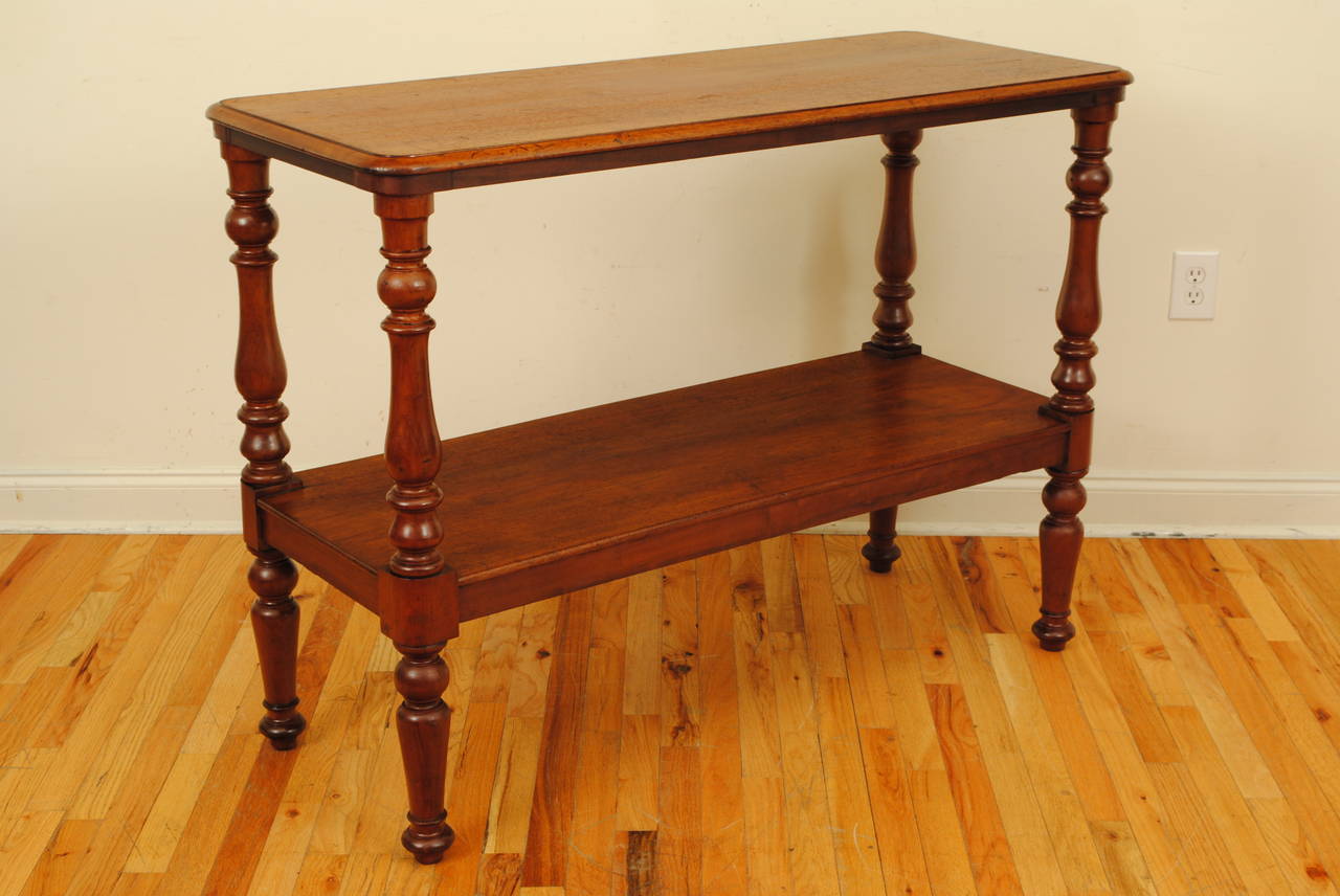 The rectangular top with rounded edges atop four turned legs interrupted by a middle shelf, structurally very sound and level.