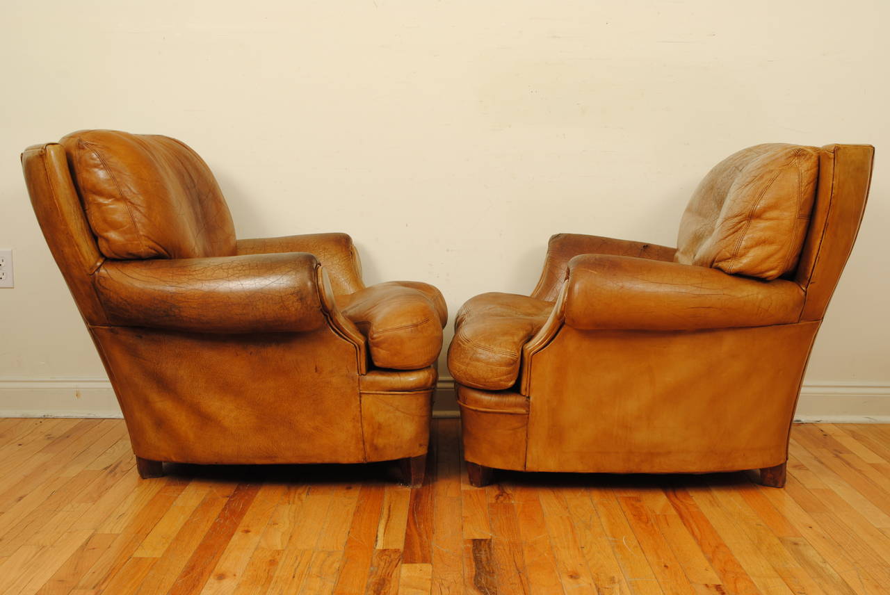 Having curved backs and down filled cushions with splayed arms and raised in small square tapering legs, nearly identical except for the cushion configuration.