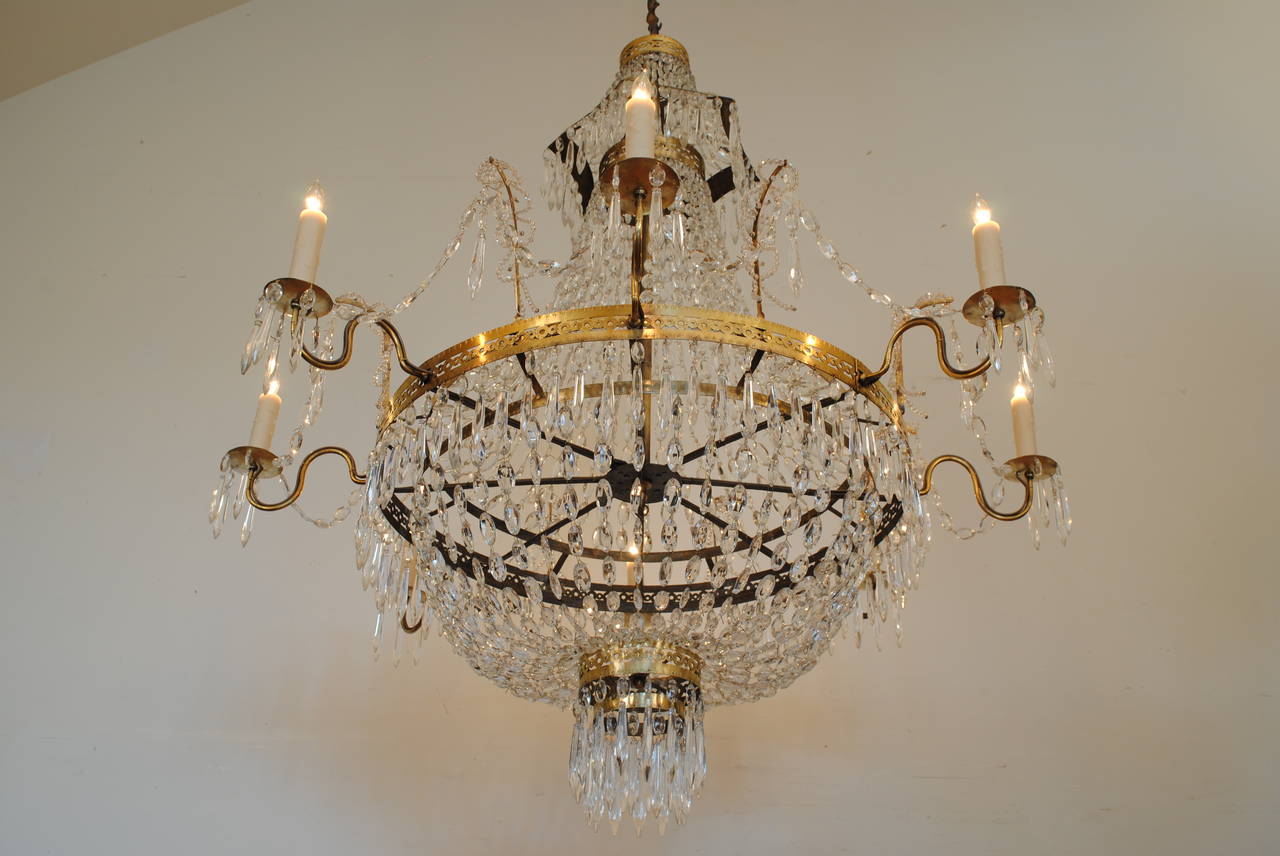 Eight-light chandelier, second quarter of the 19th century. UL wired, beautifully cast and incised brass, all rings with matching piercings and patterns, the top with a pagoda shape, having antique bead chains and prisms, out wired.