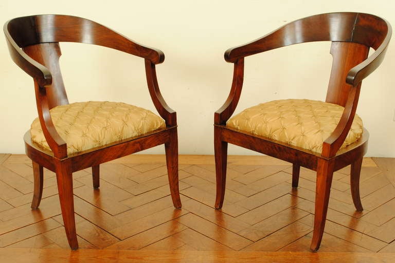 with a concave or C-shaped back, with sides that slope continuously down towards the seat, and with splayed saber legs in front and back, the arms, too, curve forward, developed in France circa 1760, the style is characteristic of Neo-Classical,