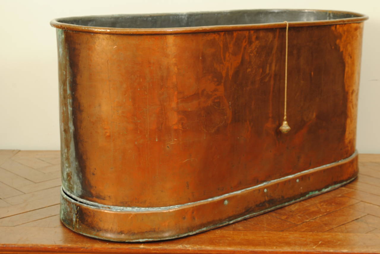 Of oval form and of two-piece construction, the bottom plinth with a wooden frame, lined in zinc and retaining original "floater" stopper, early second quarter of the 19th century.