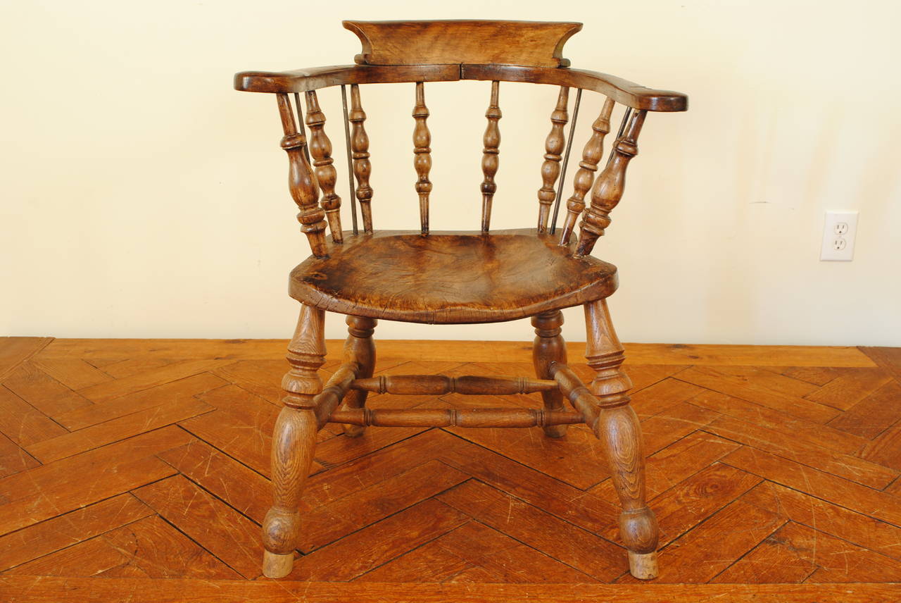Curved backrest with carved upper section, turned supports, one board seat on splayed turned legs joined by a double H-stretcher.