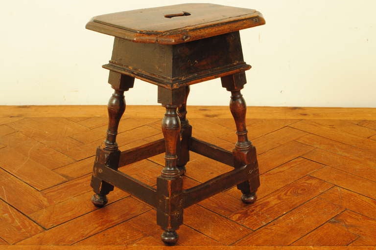 carved walnut stool or small table consisting of turned legs with a straight stretcher, top with curved opening
