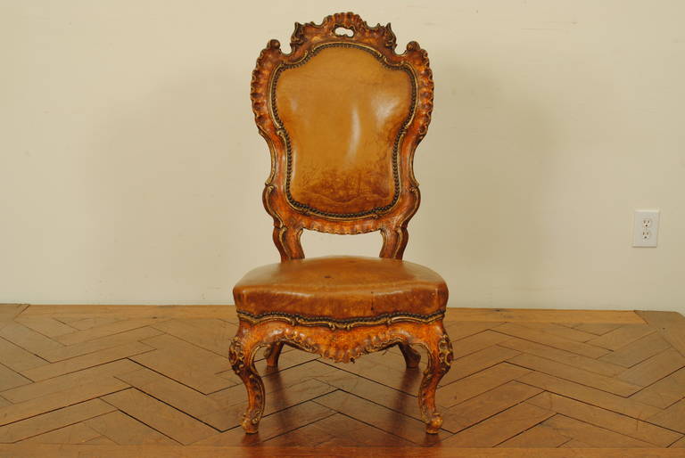 the shaped backrest with rocaille carving above a padded seat with rocaille carved apron and carved cabriole legs, the rear legs splayed