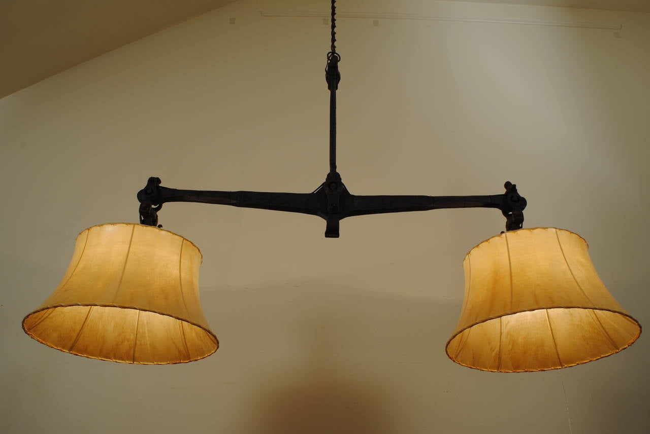 heavy and constructed entirely of steel with a center pendulum and smaller pendulums on the ends, the hooks were used for hanging loads for weighing, dated 1706, the shades are hide and are included