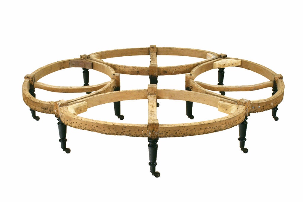 the domed top with a removable upholstered disk (the well used for a floral or plant decoration)continuing to four curved backrests above four large seats or settees, the entire framework resting on twelve turned and ebonized legs, all retaining