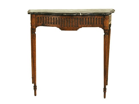 the serpentine Grigio Carnico antique (possibly original) marble top above a conforming frame of pegged construction with spaced vertical carvings on three sides resting on tall tapering reeded legs and tapering feet

Please go to www.robuck.co to