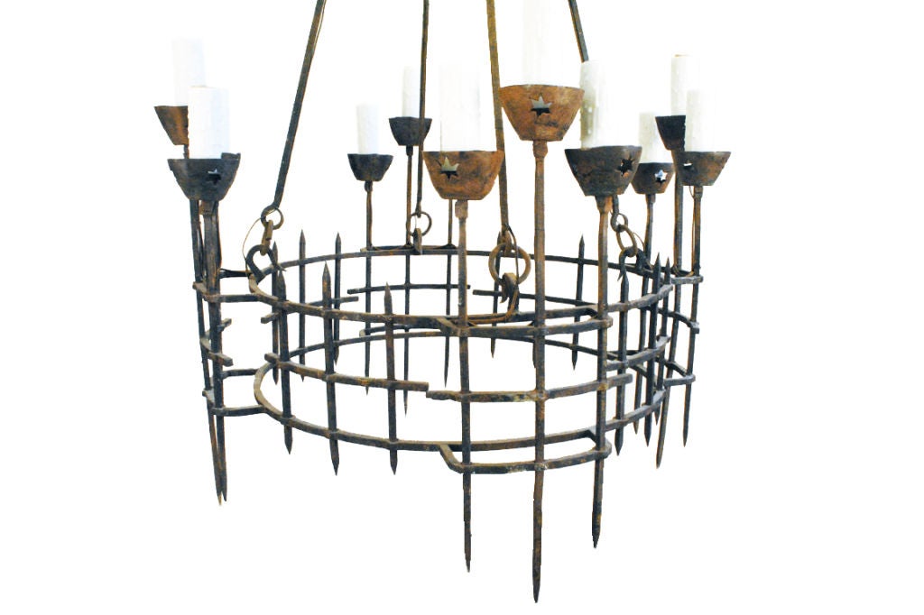 hanging from a four sided canopy, the rods connected by quatrefoils and continuing to a cage-form body with four sets of three light extending further outside, the iron bobeches with pierced stars

Please go to www.robuck.co to see our complete