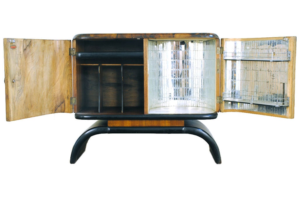 covered in burl walnut veneer, with ebonized trim and brass hardware, the interior fitted with record shelves and a mirrored and lighted bar