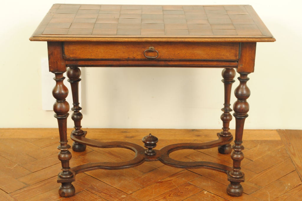 the rectangular top in parquetry above one drawer and supported by nicely turned legs joined by a shaped stretcher with a middle finial