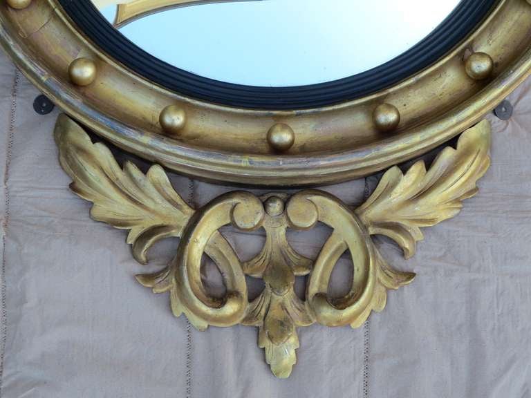 19th century American giltwood carved convex mirror.