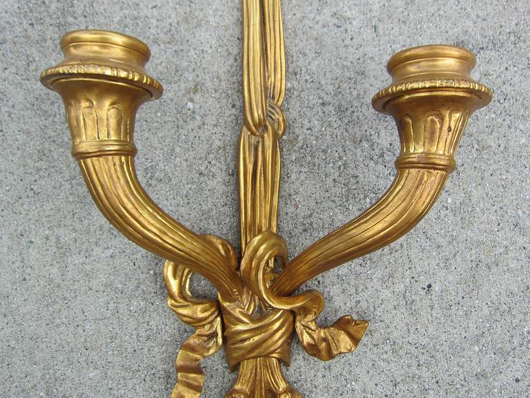 Pair of late 19th to early 20th century, Louis XVI style fire gilded bronze sconces.