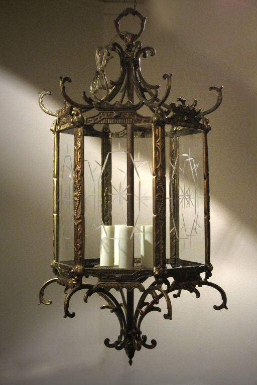 # V501 - Regency style hexagonal gilt brass hall lantern in the chinoiserie taste. The fanciful Pagoda inspired top (repeated at the bottom) above brass ribs with foliate details flanking six panels of decoratively engraved glass. 
English, early