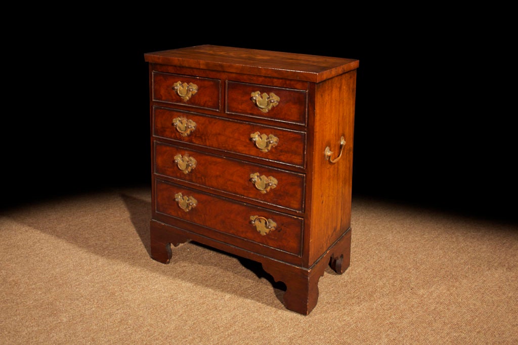 # T071 - English, Georgian style mahogany miniature chest, the rectangular top above five drawers figured in rich mahogany with a molded edge and brass fittings with a beautifully shaped backplate all raised on shaped bracket feet. The small size is