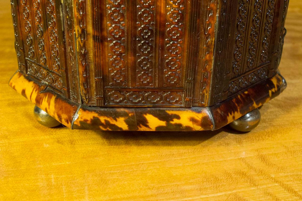 # ZA660 - Octagonal pressed tortoiseshell tea caddy having brass finial and brass round feet.
English, Circa 1820

Click on 