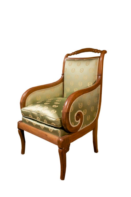 # W513 - Charles X walnut bergère surmounted by a graceful arched ball and reel open top rail. The comfortable upholstered back and seat is flanked by scrolled arms and all raised on volute carved saber legs.
For related examples see 