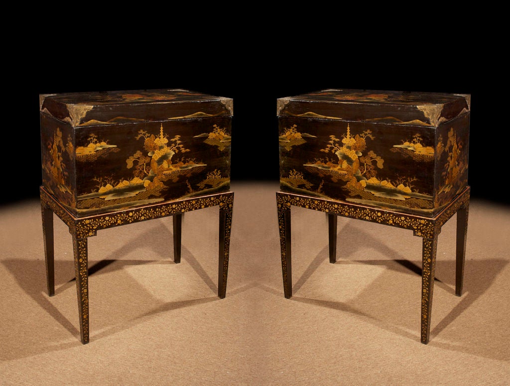 Decorative PAIR Chinese Export lacquered trunks on stands. The black lacquered ground heightened with gilt chinoiserie depicting classical landscapes with pagodas. The rectangular lids with gilt etched brass corners. The black lacquered stands with