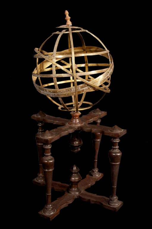 Brass armillary sphere with hour circle at pole, calibrated and adjustable equatorial and meridian rings, the large equatorial ring inscribed with signs of the zodiac, on a Baroque style turned and ebonized wooden stand.<br />
These decorative