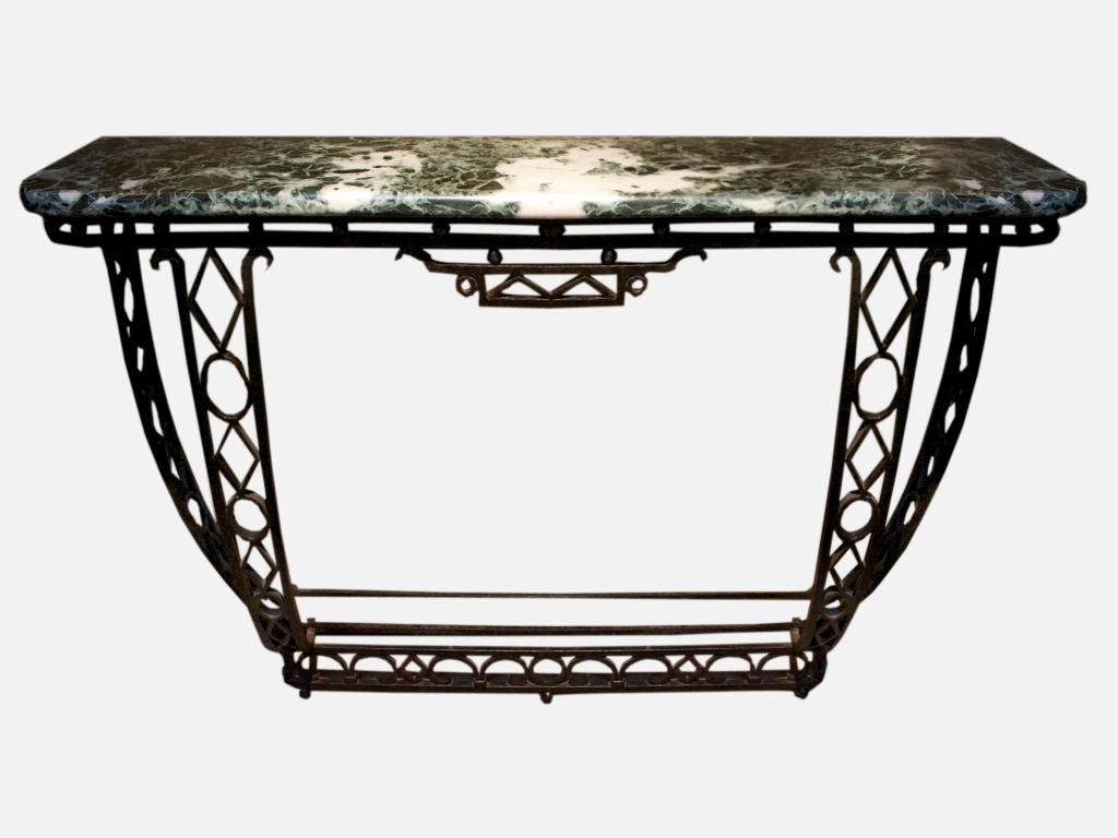 French wrought iron console table having a beautifully grained marble top over a hand worked hammered iron base. The down swept legs united by a stretcher all with decorative openwork raised on ball feet. <br />
See “Art Deco Decorative Ironwork”