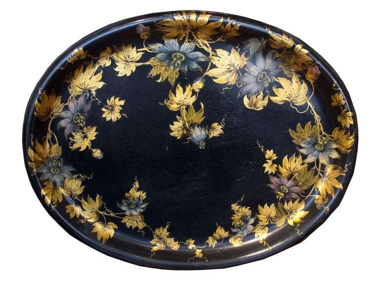 # N095 - Victorian black lacquer papier mâché oval-shaped tray with gilt foliate and polychrome flower decoration. The passion flower and vine is a rare subject.

See 