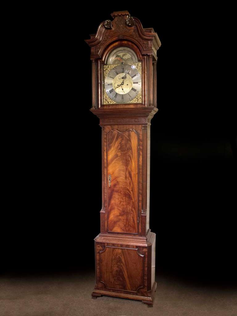 # ZA1017, Mid Georgian tall case clock executed in beautifully figured mahogany with carved enrichments and moldings. The brass dial, inscribed James Whitworth, Lussley, with a moon phase and eight day movement all surmounted by a graceful swan neck