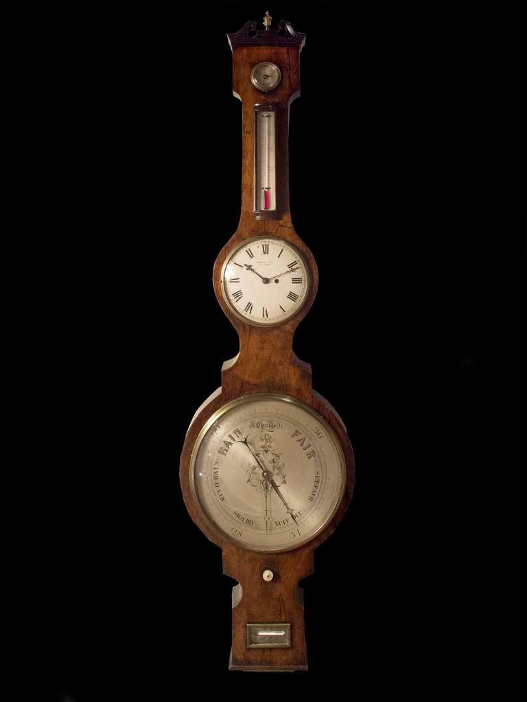 # A1018 - Large scale Mid Georgian wheel barometer and clock the dial engraved by the maker, Thomas lea. It is rare to incorporate a clock as well as the thermometer and barometer. The shaped case executed in mahogany surmounted by a swan neck