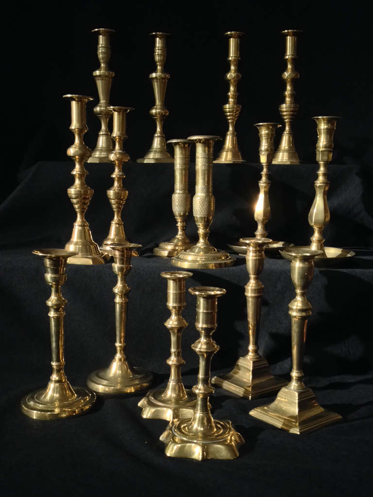 # ZA1036 - A fine set of seven pairs of brass candlesticks. The earliest are in the foreground and are English, mid-18th century baluster type measuring 7” tall. The tallest are 10” and are in the background and are English, mid-19th century beehive