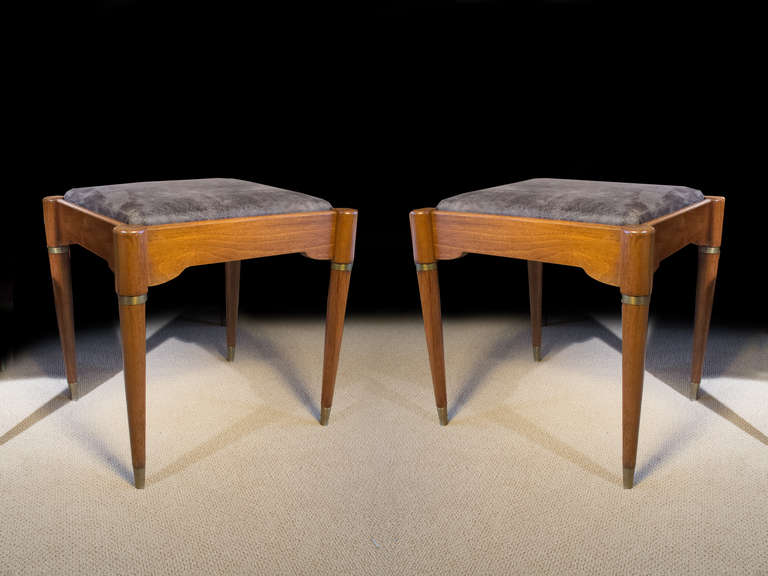 # A528 - Matched PAIR Mid-Century modern stools having rectangular slip in seats on mahogany frames with brass banding and brass feet. The subtle shape of the frieze meets out stepped round tapering legs.
American, Mid 20th C

* Click on 