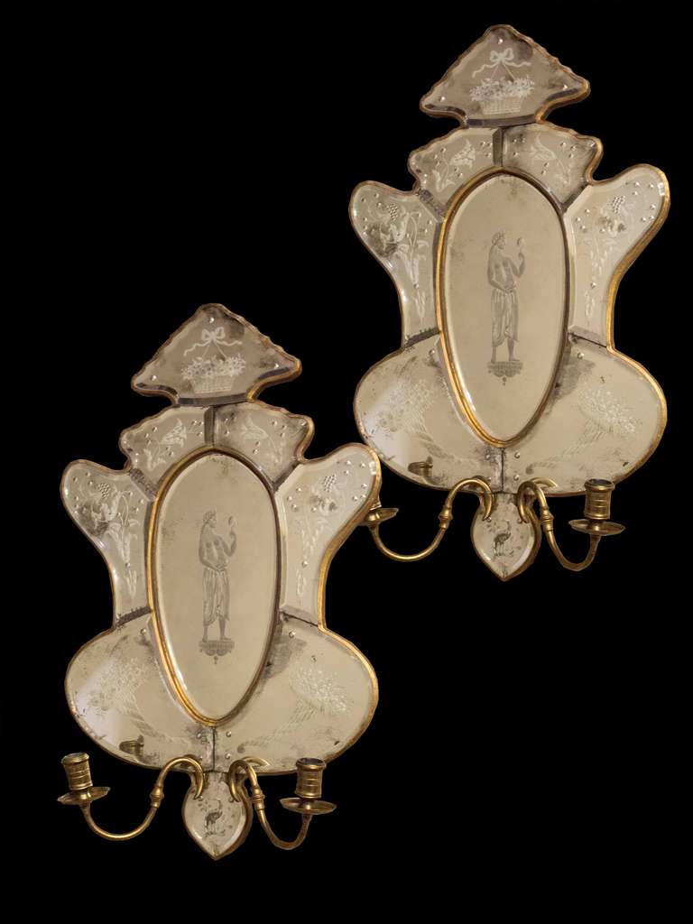 # A1041 -Pair of Venetian style mirror back wall sconces. The central oval mirror plate engraved with figure and surrounded by further shaped mirror plates each with engraved foliate details, each with a pair of candle arms. 

Italian, 19th