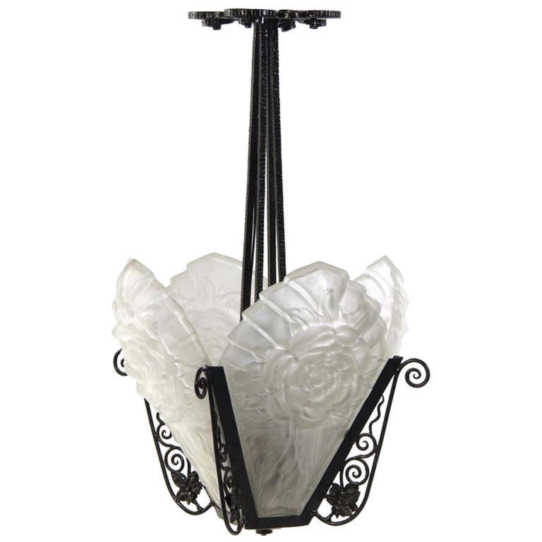 # ZA1071 fine French Art Deco wrought Iron fixture in the manner of Edgar Brandt with frosted low relief glass shades after R.J. Lalique.
The pierced decorative canopy holds the four tapering supports with four pierced iron brackets with flower and