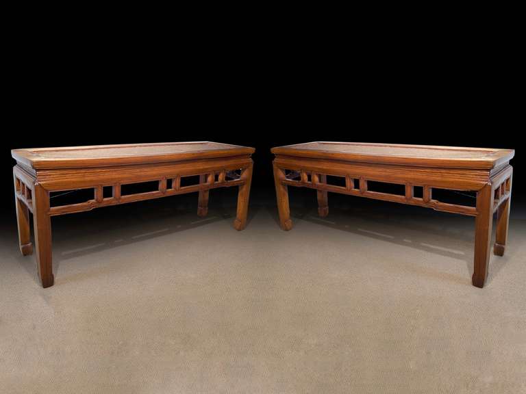 # ZA1021 - Pair of Chinese low tables or benches executed in huanghuali. The rectangular top with inset rattan panels. The frieze with pierced carving. See 