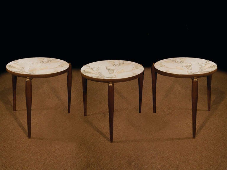 # W075 - Set three Mid-Century Modern stacking tables with round shaped tops and brass details. Note the simplicity of the construction with attenuated round legs holding the framed faux marble tops.
American, circa 1950.

See similar examples of