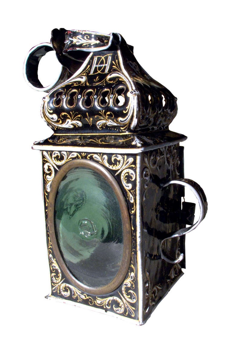 # W121 - French enameled miniature lantern with superb gold and white finely detailed decoration on a black ground. Three of the four sides with oval bulls eye glass, one of which opens to allow the placement of a small candle. The shaped top with