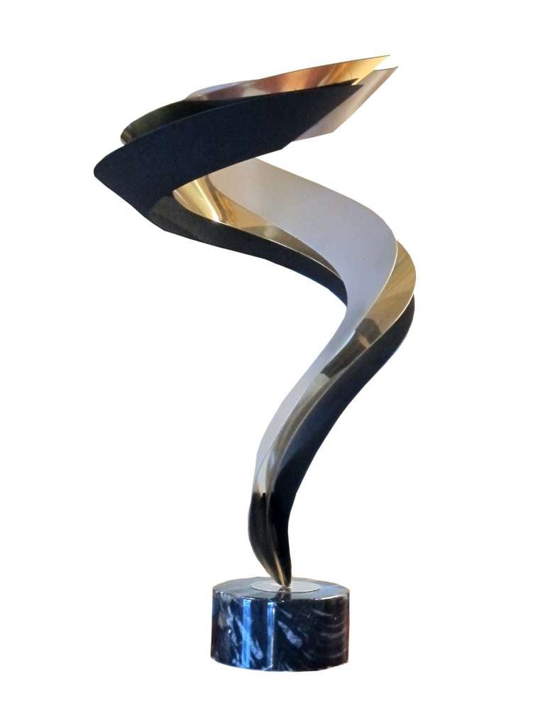 Abstract Metal Sculpture by Curtis Jere. The three spiral bands, patinated black gold and silver curl up and outward. Rotating on a marble plinth base. American, 1960- 1980 (# ZA615)
Curtis Jere is a compound nom-de-plume of artists Curtis Freiler
