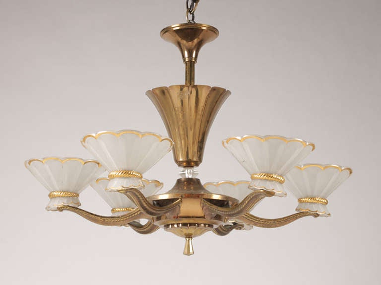 # Y086 - French Art Deco metal chandelier having stylized tulip form central stem over faceted glass ball supporting six scrolling arms each fitted with a scalloped frosted shade enriched with faux metal details.
French, circa 1930.

See similar