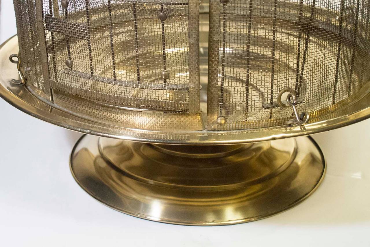 # ZA634 - Brass round bird cage raised on a short pedestal.
Early 20th Century

* Click on 
