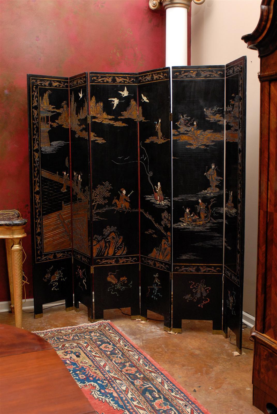 A beautiful double-sided six-panel folding screen. One side is a village scene in golds, ivory and orange with a black background. The opposite side has flower and bird patterns. Each panel is 16 inches.