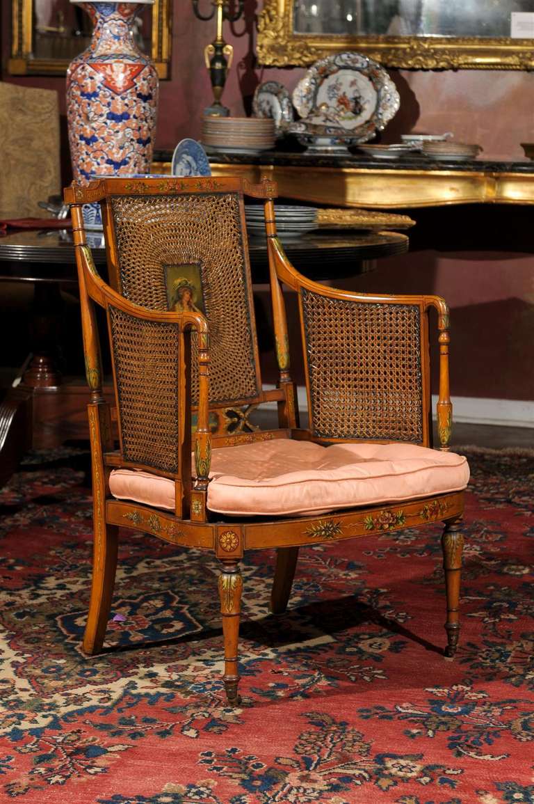 This is  rare and beautiful ! It has painted cartouche centering, caned back, bowed seat rail on turned legs with casters and a fitted seat cushion